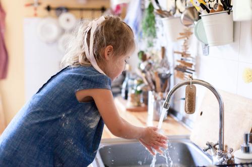 Gyermek kezet mos a tanulótorony segítségével 