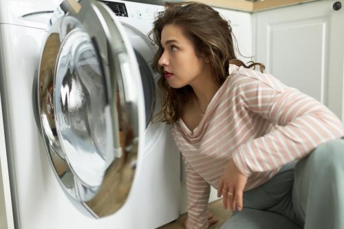 Nő a mosógép előtt