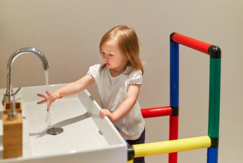Tanulótornyon álló kislány kezet mos