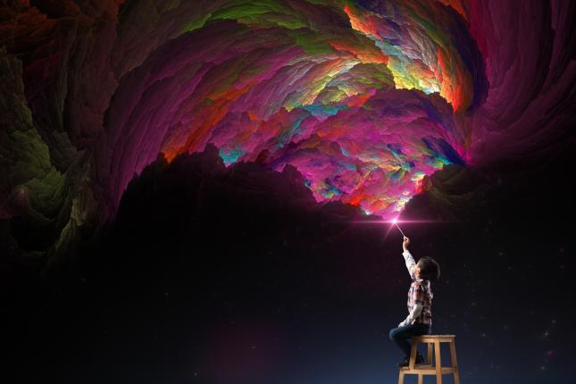 Boy painting fantasy clouds in the air